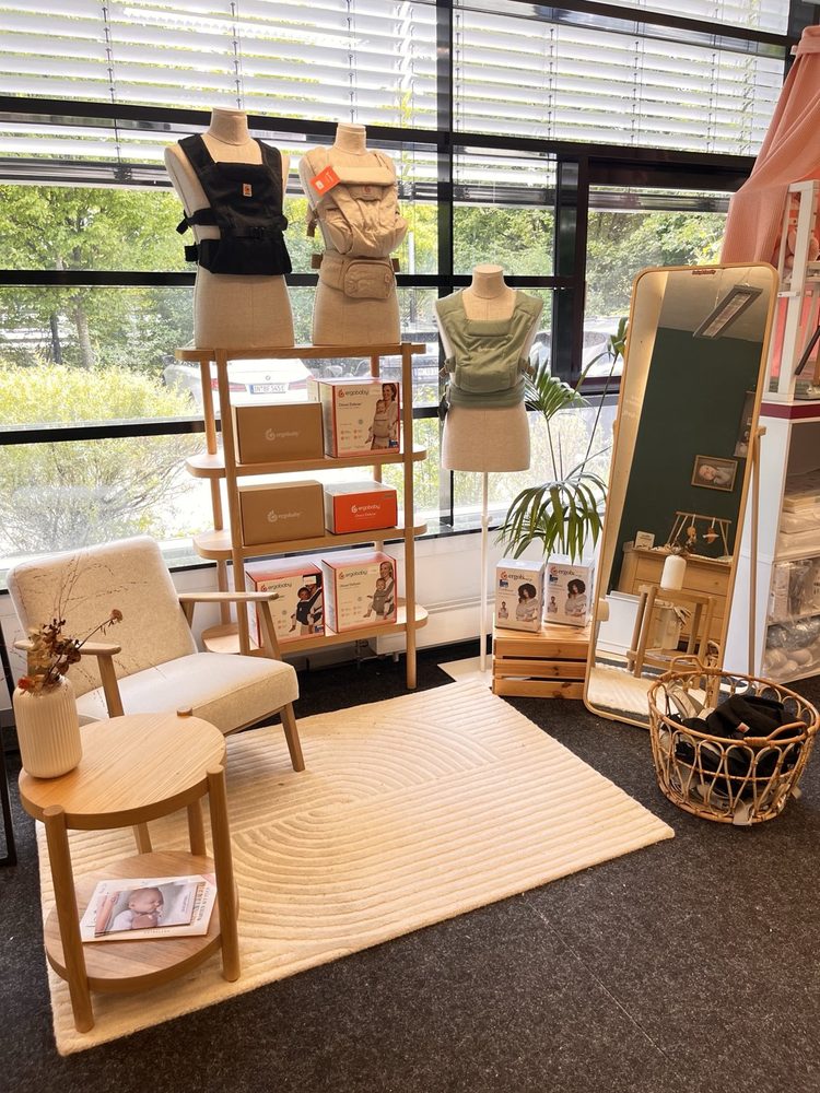 Ergobaby-Shop-in-Shop mit Babytragen, Sessel und Spiegel im Fachhandel