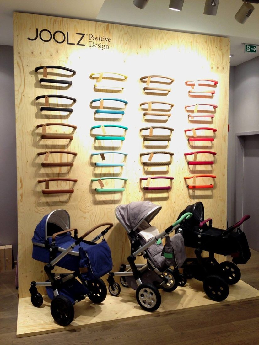 Joolz-Shop-in-Shop mit Holzwand, farbigen Schiebebügeln und Kinderwagen bei Baby Kochs in Düsseldorf