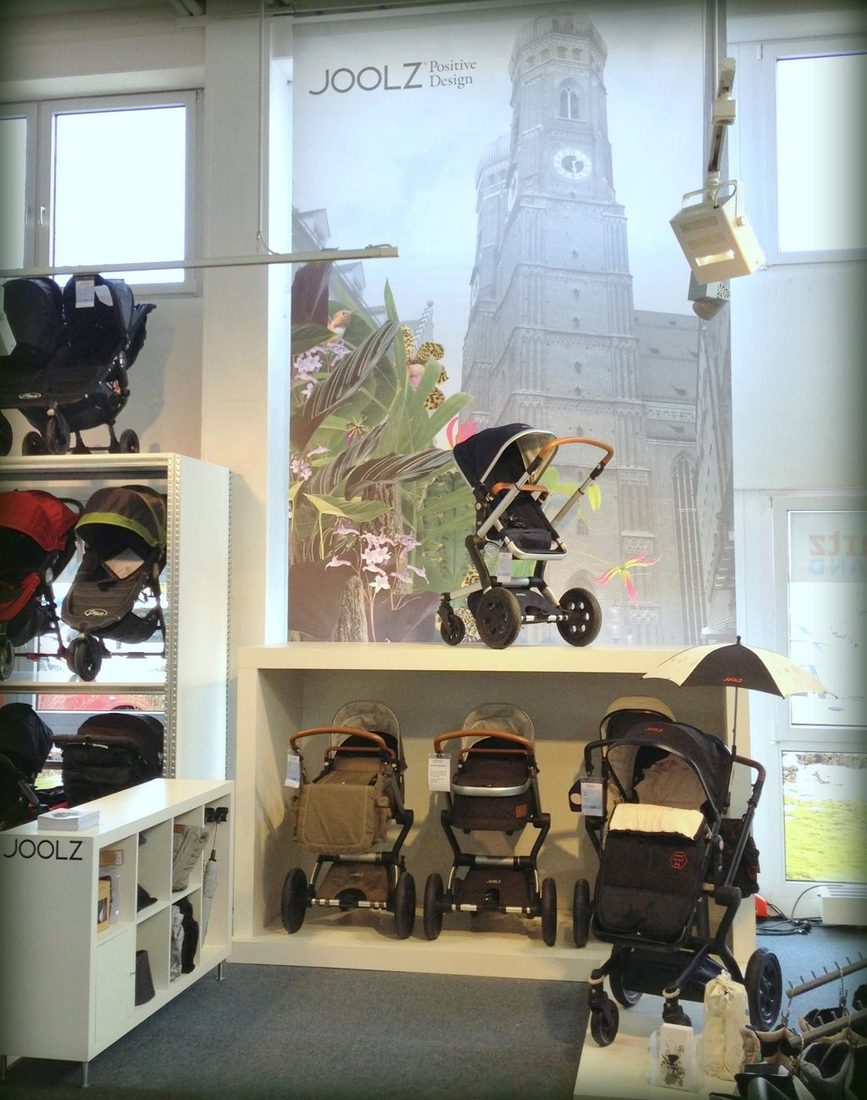 Joolz-Shop-in-Shop mit Kinderwagen vor einem Wandbild der Münchner Frauenkirche bei Reinartz in München